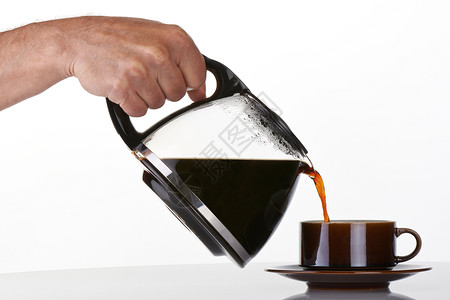 将咖啡倒进棕色的杯子里喝着咖啡玻璃水瓶手锅图片