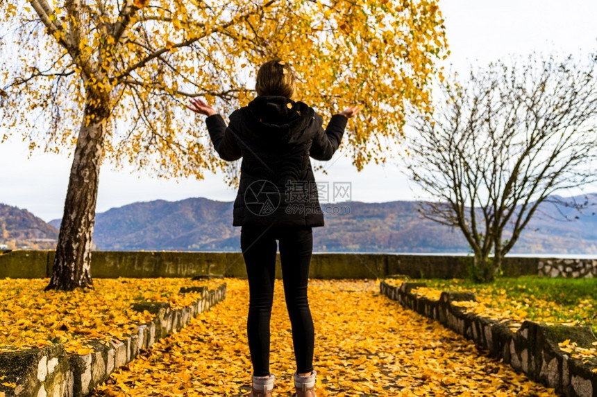 秋天的落叶在独自走秋天小巷的女人身上秋天的风景罗马尼亚奥尔索瓦公园里的橙色树叶20年秋天的树叶落在独自走秋天小巷上的女人身秋天的图片