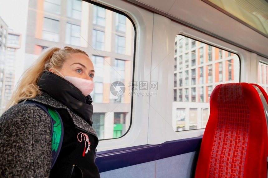 社会的健康由于冠状有卫生面罩的妇女可以在火车座椅上保持安全距离因为冠状手机图片