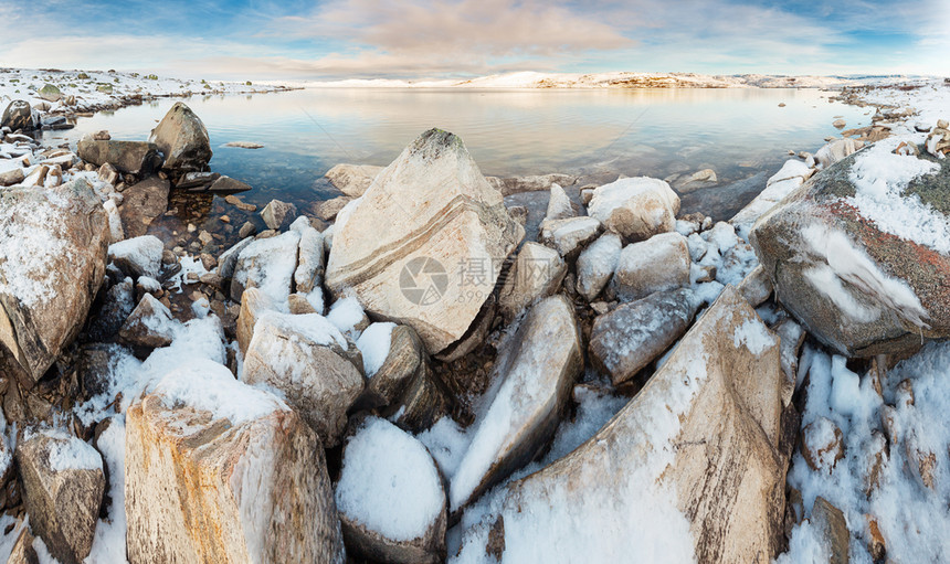 旅行前景日落时挪威湖的全景地表有雪覆盖的岩石田园诗般图片