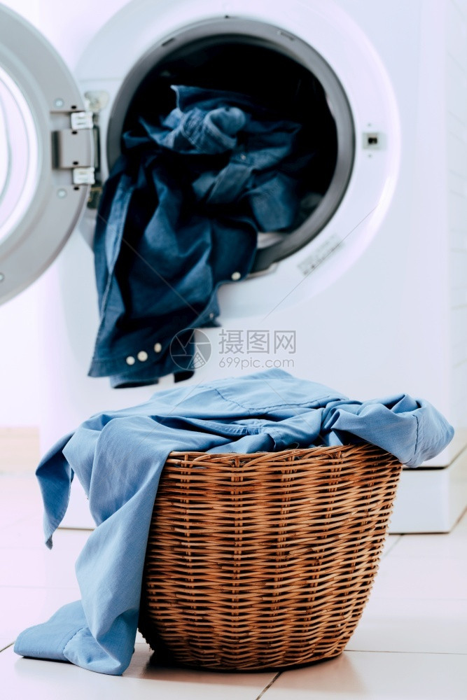 将洗衣机和服装在篮子中的白色背景洗涤机和衣物干燥金属电子的图片