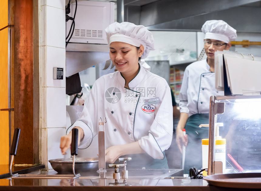 2018年9月日018年轻的意大利面食厨师在披萨餐厅的柜台后面做意大利白酱食物职业制服图片