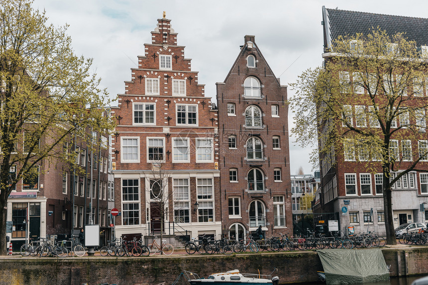 正面晚上具有阿姆斯特丹河流运漂亮房子的可舒适欧洲建筑速连科图片