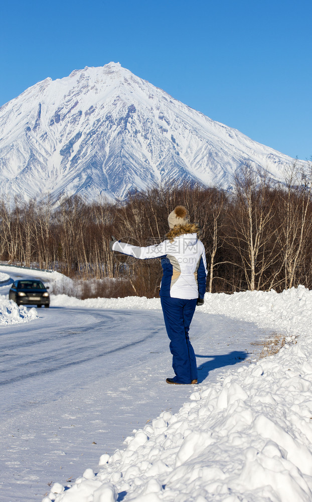 常设旅游女孩搭乘在火山对面的冬季公路上游客图片