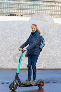 垂直的f在芬兰公路上驾驶电动摩托车的妇女城市辆电的高清图片素材