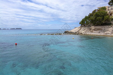 绿色海岸线滨西班牙马洛卡海岸附近的松绿红浮标和地平线马洛卡岛图片