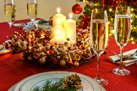 玻璃漂亮的装饰圣诞餐桌香槟和餐桌具的杯子配上红桌布的圣诞装饰美丽金图片