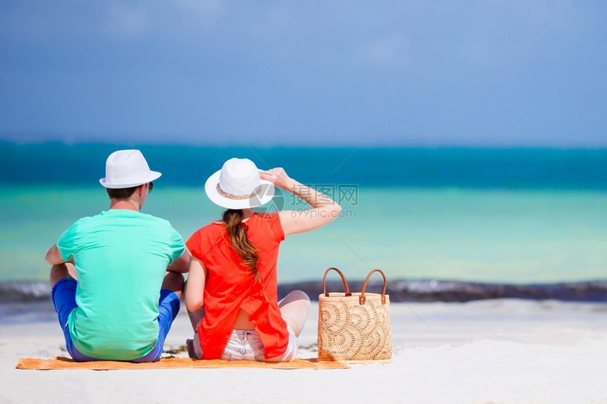 旅游年轻快乐的情侣在海滩度假期间玩得开心在白色海滩上的夫妇穿着红衬衫和沙袋的白海滩上女人们自然图片