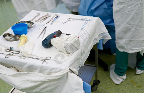 医疗的电盆地真正手术室桌上的外科手术器械图片