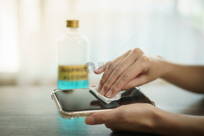 水用手将乙基酒精从瓶装倒入棉花片用于清洁移动电话冠状或Covid19保护乙醇干净的图片