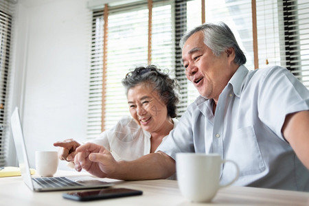 祖父母放松的亚洲老年夫妇通过视频电话和在笔记本脑上与家人交谈快乐笑日本长老男女在家享受互联网技术生活风格乐趣等游戏愉快人数字的高清图片素材