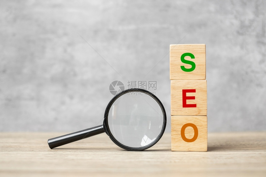 保持排行信息SEO搜索引擎SEO最佳优化文本木立方块和手握表Idea战略广告营销关键词和内容概念上的放大玻璃