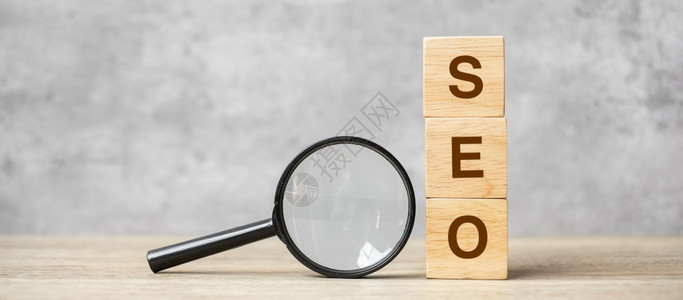 互联网络空间托管SEO搜索引擎SEO最佳优化文本木立方块和手握表Idea战略广告营销关键词和内容概念上的放大玻璃放大镜高清图片素材