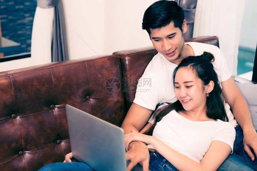 亚洲人英俊的恋使用笔记本电脑的爱人和情侣概念的亚洲年轻夫妇蜂蜜月和婚礼主题内与约会图片