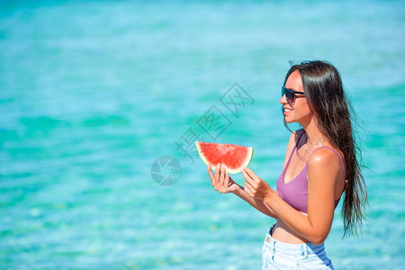 女人在沙滩上吃西瓜图片