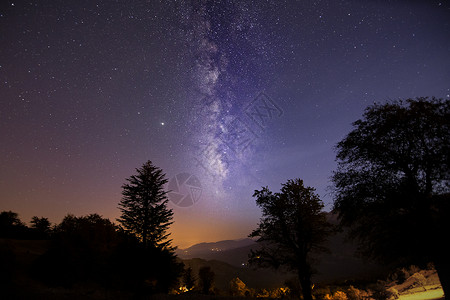星空银河系和树木剪影图片