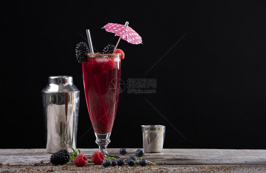 冰沙果味茶点以黑莓和摇晃器装饰的木制基地上玻璃杯中果子鸡尾酒图片
