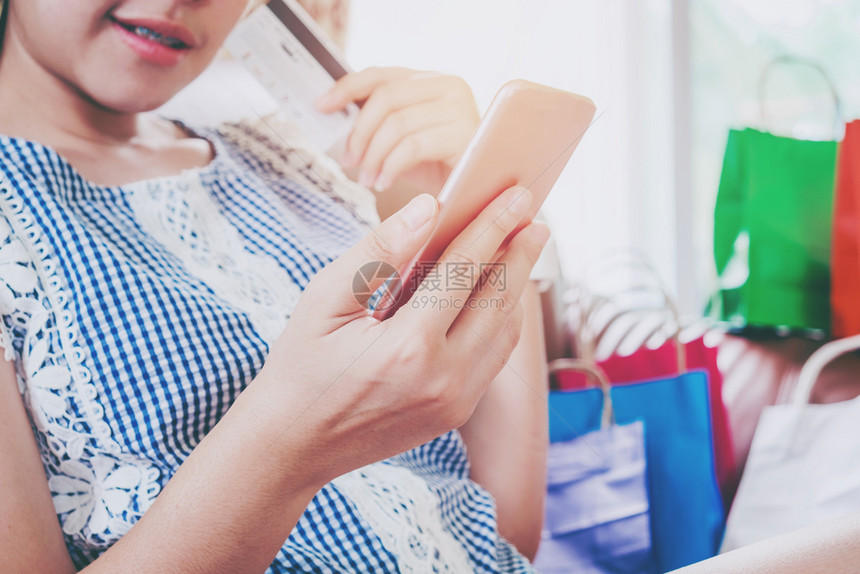 妇女利用智能手机信卡在家中享受的信用卡在线购物电子商务社会的人们图片