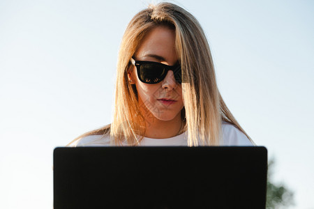 坐在橄榄树田里的拥有笔记本电脑的年轻妇女金发郎农学家研究员图片