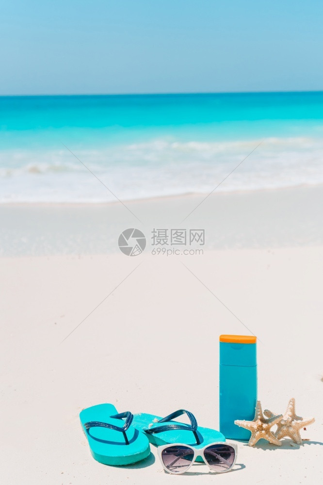 人字拖白色沙滩背景海洋上的触发器防晒霜瓶护目镜海星和太阳白色沙滩背景海洋上的防晒霜瓶海星和太阳镜夏天异国情调图片