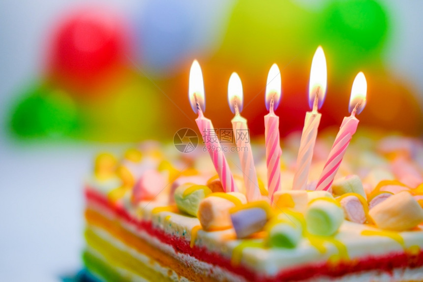 节日色彩缤纷的生贺卡彩虹蛋糕上有五支燃烧的蜡烛背景上有彩色气球可口周年纪念日乐趣图片