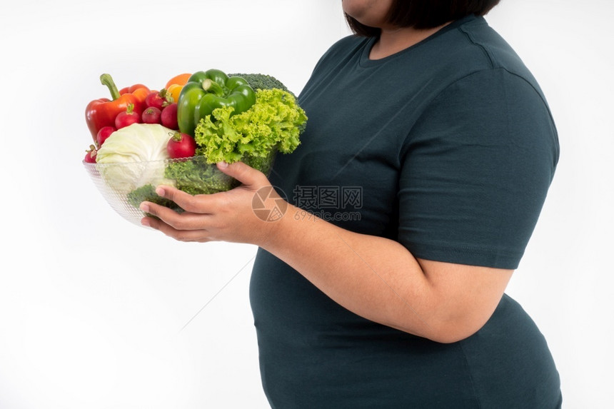 超重女孩手里拿着一碗蔬菜图片