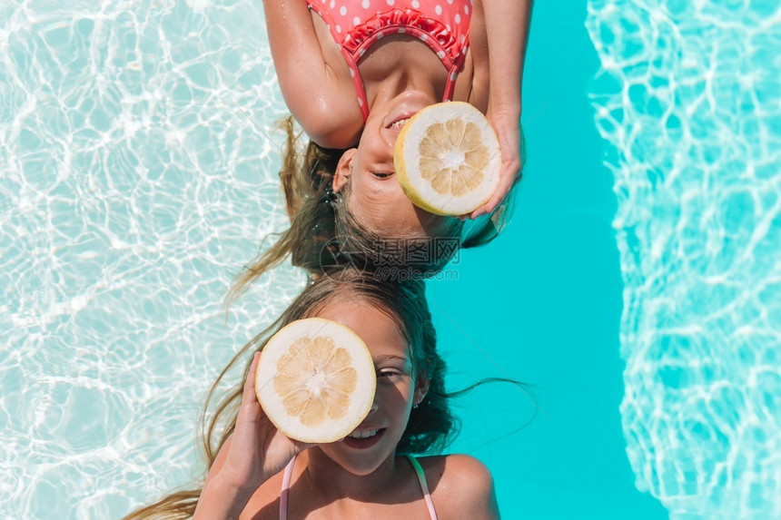 维他命节食小女孩在游泳池里对柑橘柠檬玩得开心小姑娘用柠檬眼罩着睛在背景游泳池附近看见柠檬水果图片