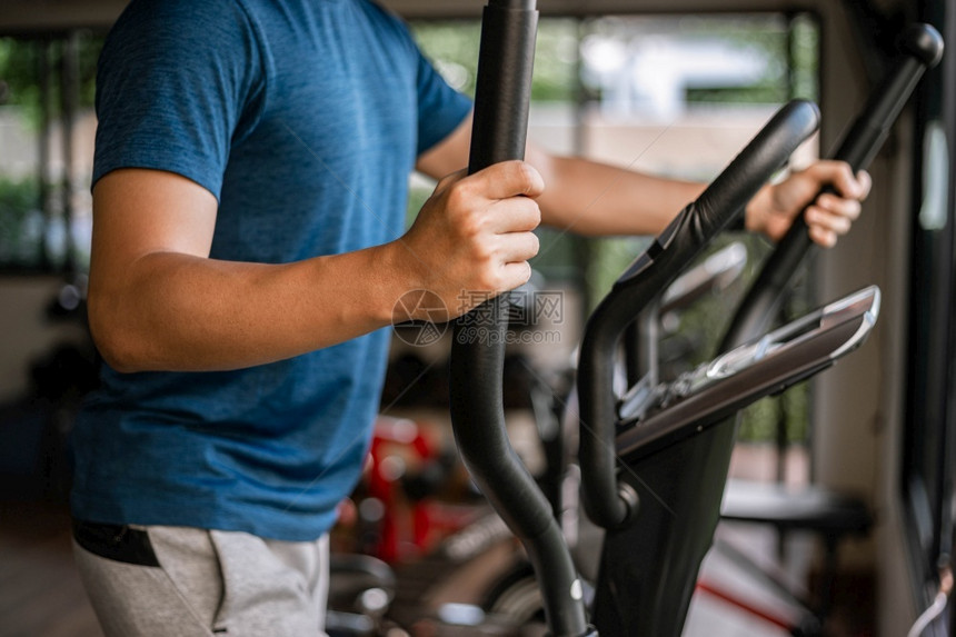 一种嬉戏的合身训练体操概念一名男青少年在健身房做心血管运动将骑自行车机作为健康日常活动图片