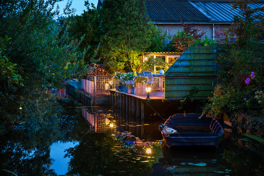 草景观晚上美丽的荷兰场有运河反射船鸭子和彩色灯光的植物船荷兰树图片