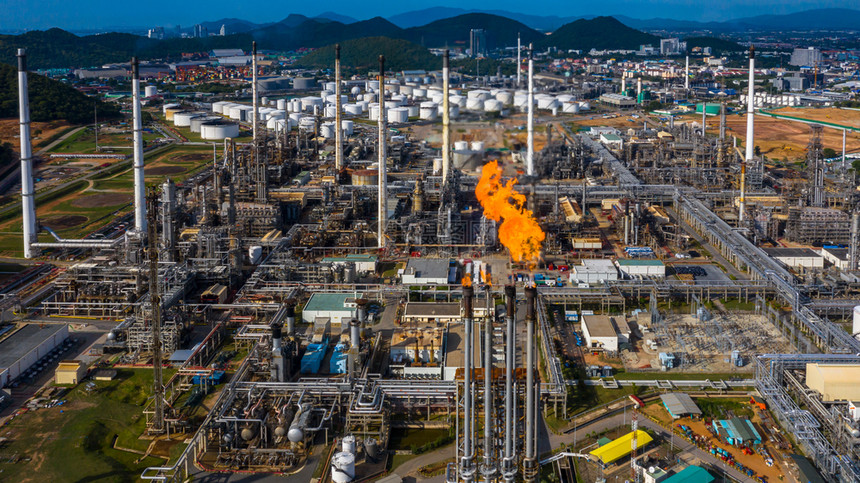 管子日间空中观察石油和天然气炼厂石化工在有火和蓝天背景的情况下工作日间观测机能和煤气炼油厂化学生态图片