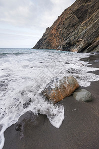 泡沫旅行在西班牙加那利群岛拉戈梅的暴风天在岩石海滩上喷洒波浪雾蓝色的背景图片