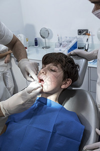 牙医检查小男孩的牙齿图片