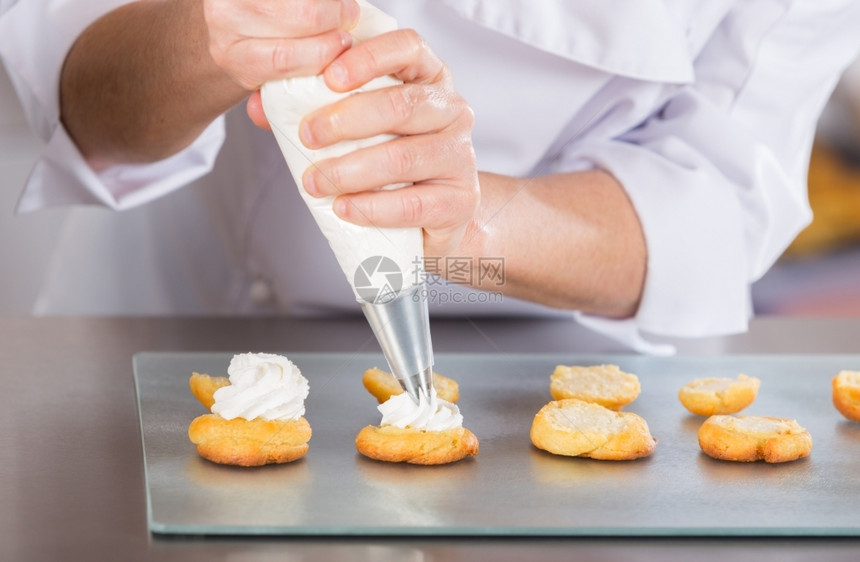 专业的手糕点厨师完成一个美味的奶油黄巧克力图片