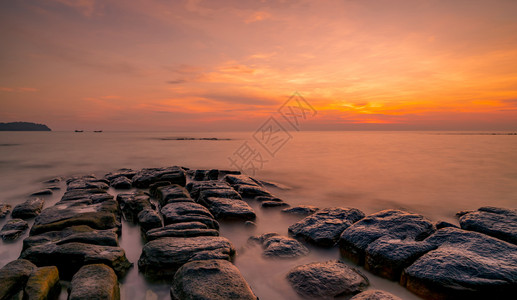 戏剧水海景日落时在石滩上的岩美丽海边夕阳天紫光海与空黄昏时的热带海风云天空和日落抽象背景平静放松生命景观背景图片