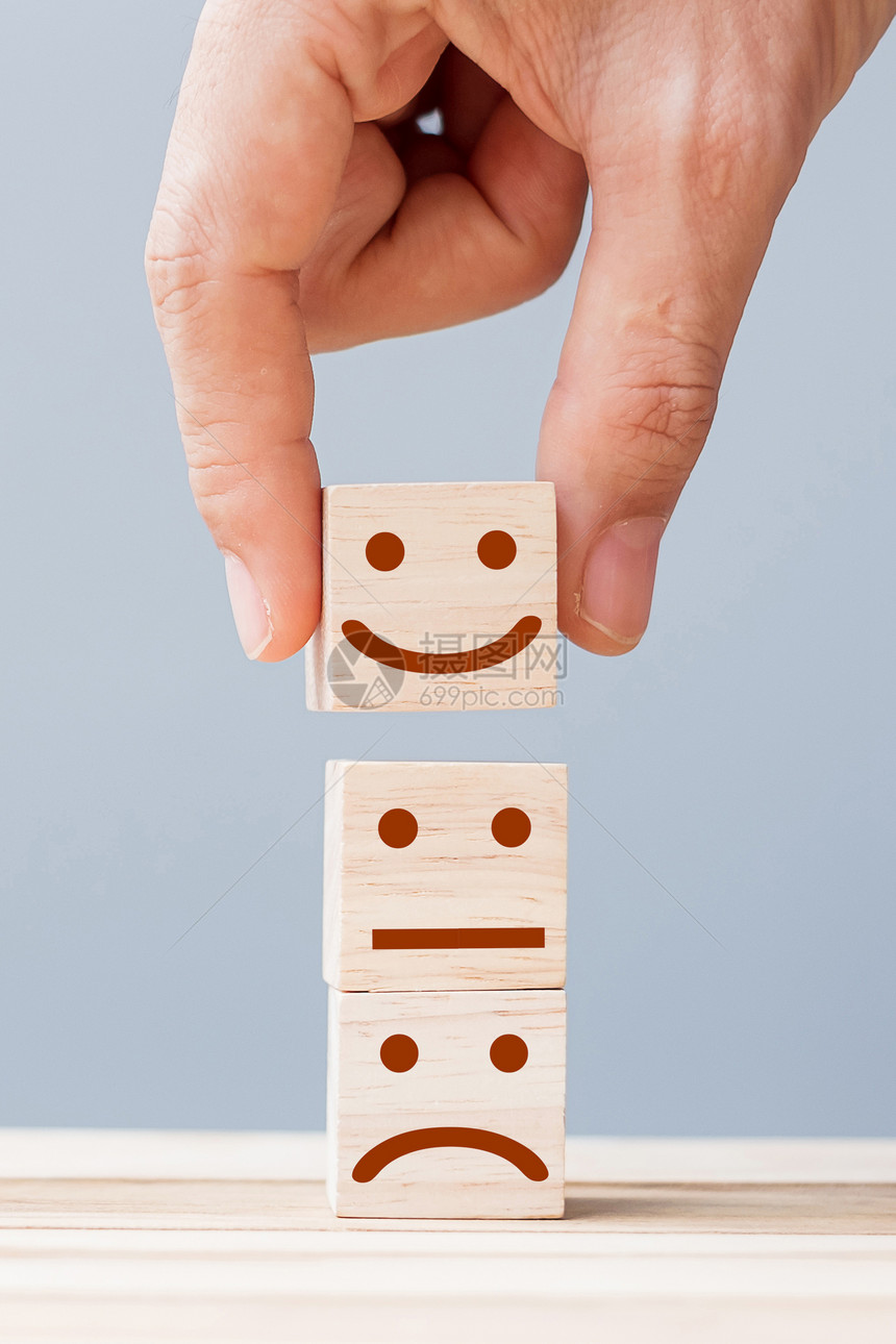 情感服务评级排名客户审查满意度和反馈概念手持微笑的脸符号在木立方块上商业网络伤心图片