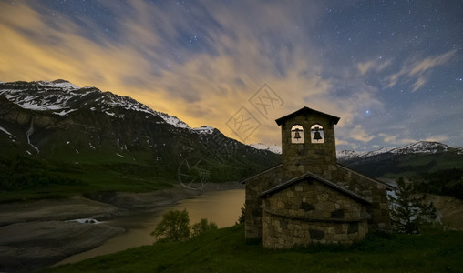 夜晚拍摄阿尔卑斯湖的风景天空有星山里移动的云教堂月球欧罗巴远足摄影图片