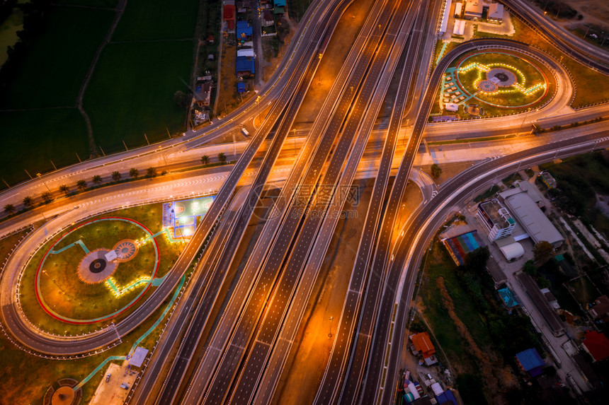灯光戒指从无人机摄像头在泰国夜间连接城市的汽车运输新环城交汇处和高速公路旁通的空中顶视图施工重要的图片