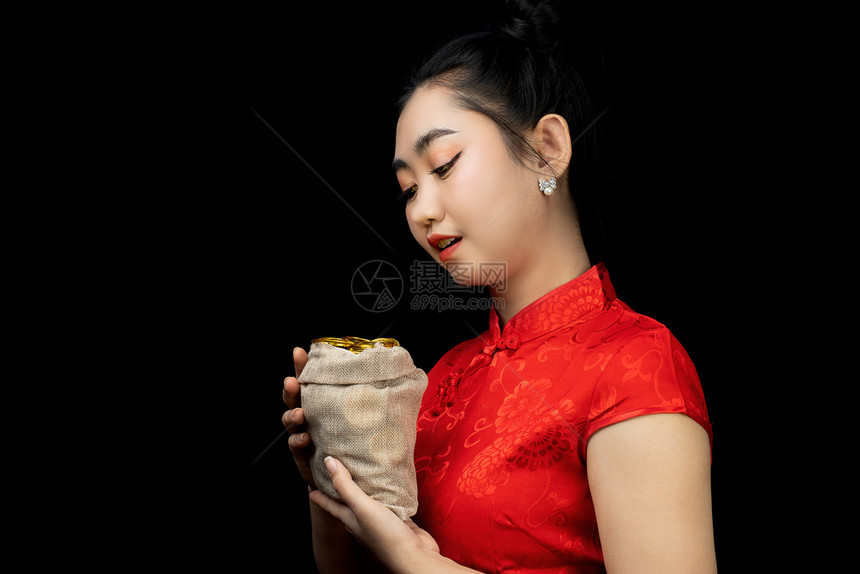 东方的快乐黑色亚洲年轻穿红礼服的亚洲女传统青森在黑背上袋中拿着金币的黑衣长袍女孩新年概念图片