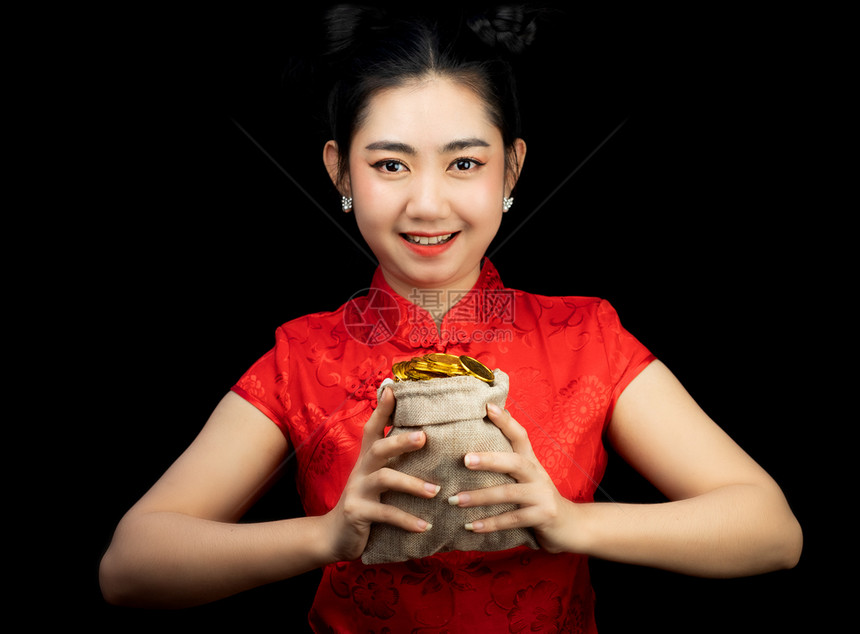 包亚洲年轻穿红礼服的亚洲女传统青森在黑背上袋中拿着金币的黑衣长袍女孩新年概念庆祝财富图片