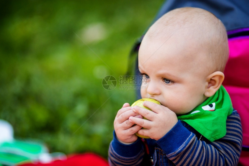 一个小孩咬了大青苹果并把它握在手里一个小孩咬了大青苹果微笑美丽的营养图片
