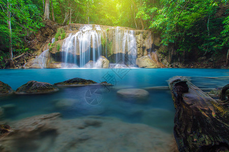 泰国Kanchanaburi深林的瀑布与树木溪深的流图片