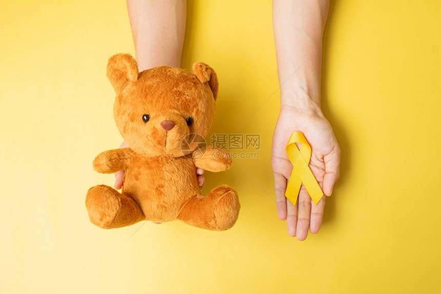 泰迪熊与黄色丝带预防癌症概念图片