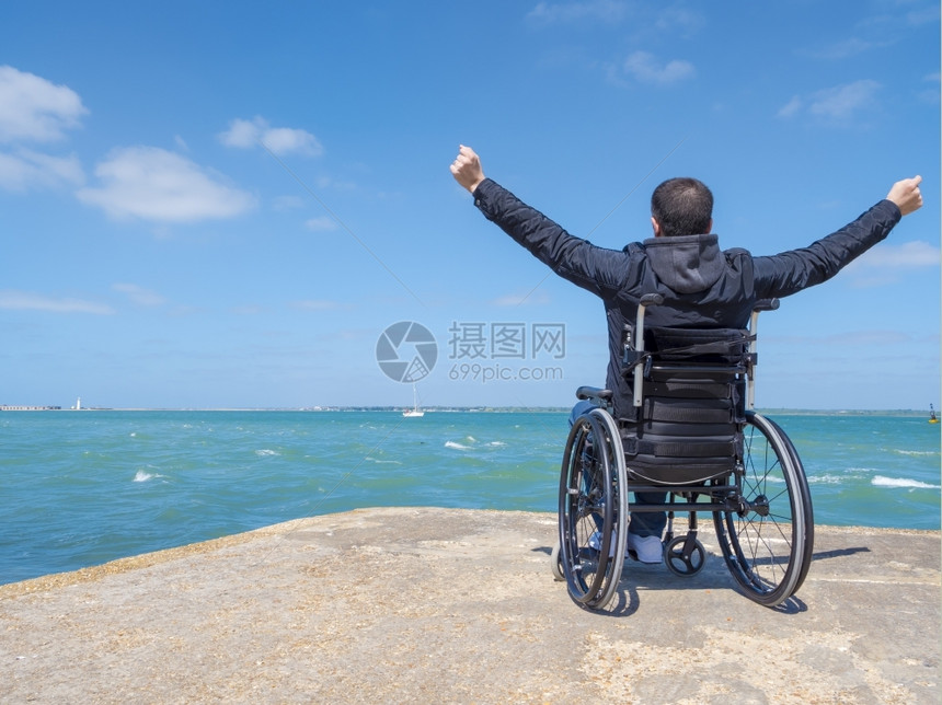 障碍坐在轮椅上看海的残疾青年男子独身残疾人景观受伤图片