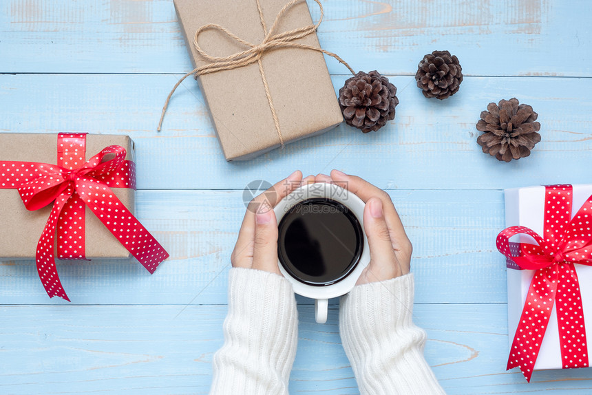 盒子杯手握黑咖啡和圣诞节装饰新年快乐和圣诞节日的女子食物图片