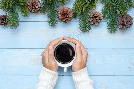 寒冷的保持雪手握黑咖啡杯和圣诞节装饰新年快乐和圣诞节日的女子图片