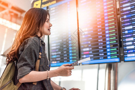 离开观察飞行时间的亚洲美容女旅游者在检查飞行时间表可以抽出间人与生活方式概念单身女主题的旅行与快乐生活BackView肖像手提箱乘客高清图片素材