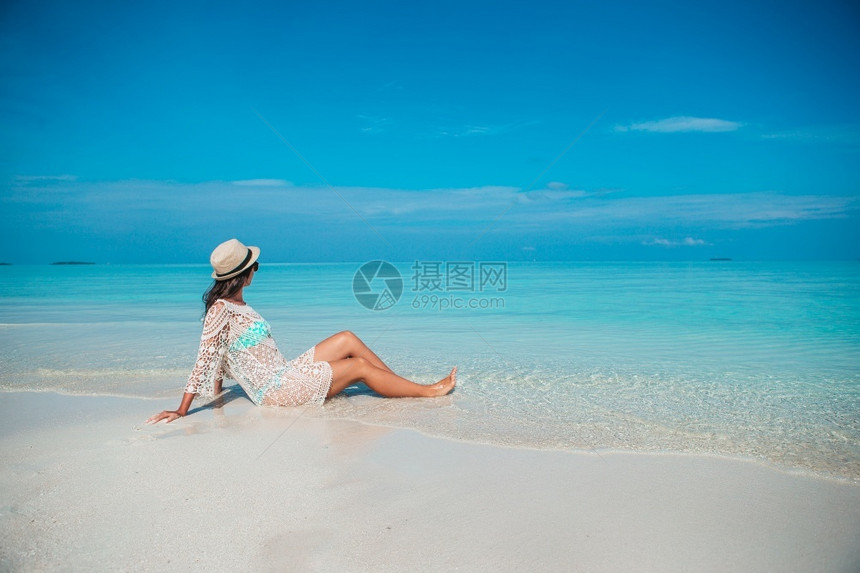 享受快乐的女子在浅水海滩上玩得开心在海滩上穿绿礼服的年轻时尚女子士太阳图片