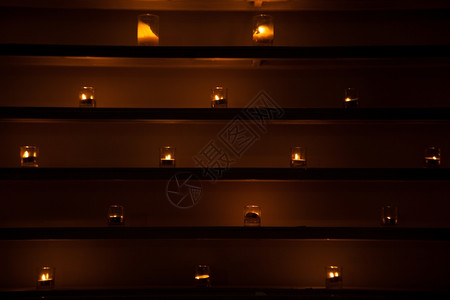 仪式盘子灯光照亮一排放在架子上的灯光芯图片