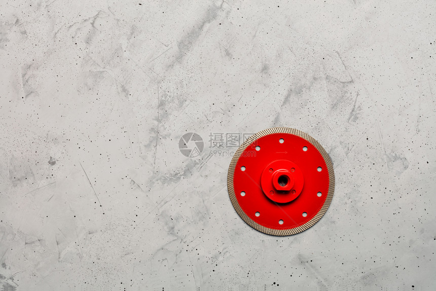 为了圆圈用钻石切割红色圆盘用一块直径125毫米的薄片和法兰花在灰色混凝土背景下精确切割材料时使用一条直径为125毫米的薄片以灰色图片
