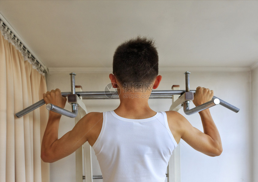 健身房苗条的练习穿白色T恤衫的青少年在家庭运动角的上做体力锻炼在家庭运动角的上做体力锻炼图片